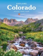 Colorado Vacation Guide: A scenic view of snow-capped Rocky Mountain peaks reflecting in a crystal clear alpine lake during summer.