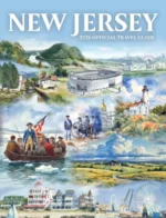 New Jersey Vacation Guide: Aerial view of a scenic New Jersey beach with a historic lighthouse and lush green state park trails in the background.