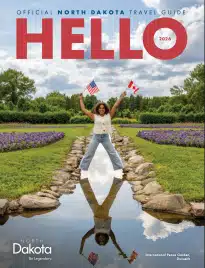 North Dakota Vacation Guide: Scenic view of the North Dakota Badlands with layered rock formations and wild bison grazing in the foreground.