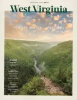 West Virginia Vacation Guide: A scenic view of the New River Gorge Bridge surrounded by lush green forests in West Virginia.